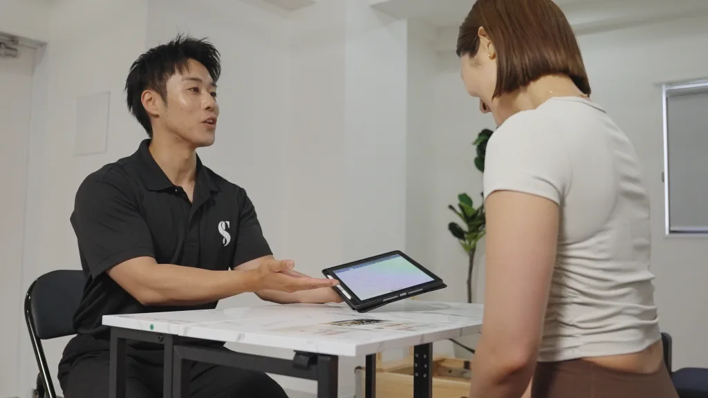 お客様と対話しながらセッション内容を確認するトレーナー